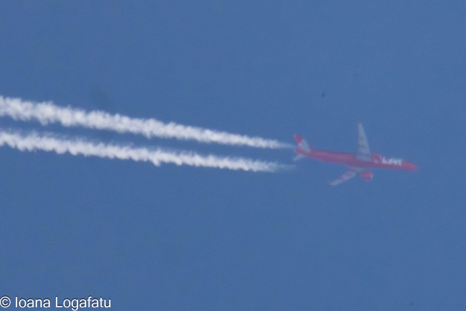 Bright blue sky with a plane leaving trails